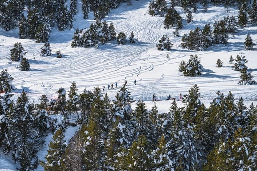 Group of people hiking on fresh snow in mountains. Huskey sleigh ride. Winter ski holidays in Andorra, El Tarter, Grandvalira, Pyrenees Mountain range