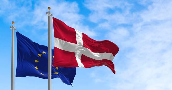 The flags of Denmark and the European Union waving together on a clear day. Denmark became a member of the European Union on January 1, 1973. Realistic 3d illustration
