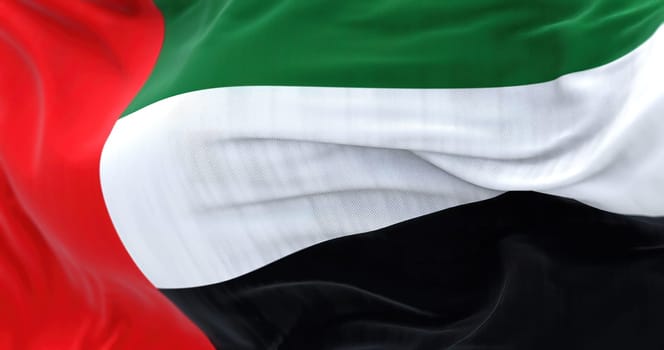 Close-up view of the United Arab Emirates national flag waving in the wind. The Emirates is a country in Western Asia. Rippled fabric. Textured background. Selective focus. Realistic 3d illustration