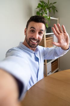 Vertical selfie picture of man at home office - camera point of view. Lifestyle and technology.