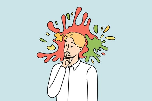 Pensive young male employee or worker with colorful splashes in head. Thoughtful businessman engaged in creative thinking. Vector illustration.