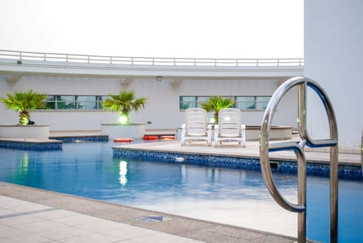 Swimming pool on the top of the roof in modern residential building in Dubai.
