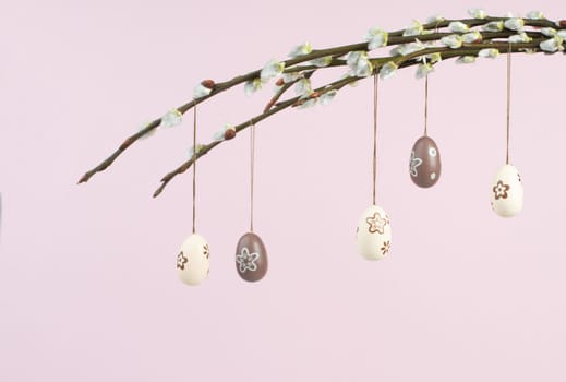 Easter holiday, small colored eggs hanging on pussy willow branches, greeting card, spring season