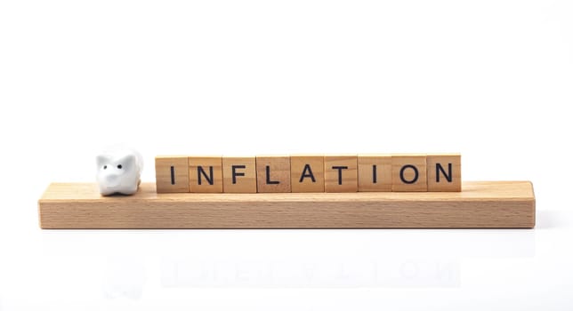 Inflation concept with letters and little piggy bank isolated ober white background