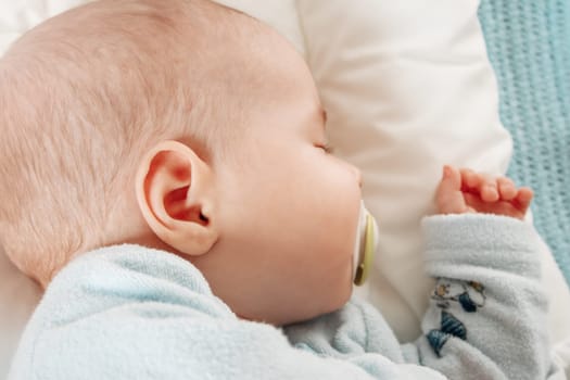Cute three month old baby sleeping in comfortable bed. Concept of the family andparenting.