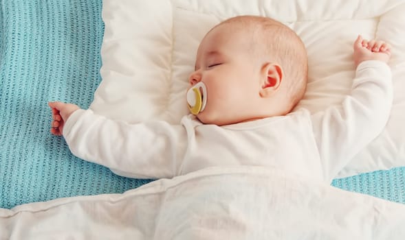 Cute three month old baby sleeping in comfortable bed. Concept of the family andparenting.