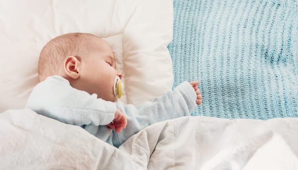 Cute three month old baby sleeping in comfortable bed. Concept of the family andparenting.