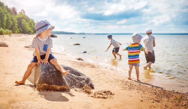 Group of children playing on the sea coast in summer. Concept of the vacation and tourism.