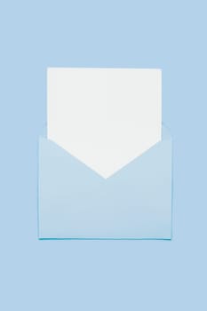 Closeup on blank empty white paper card in blue opened envelope isolated on blue pastel color background. Love letter minimal concept. Conceptual layout template with text place on postcard. Mock-up