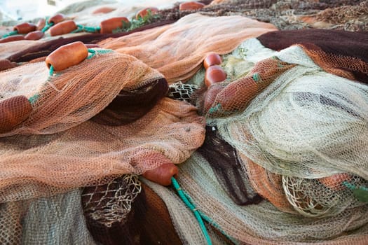 Fishing nets the Port of Corricella with lots of colorful houses on a sunny day in Procida Island, Italy.