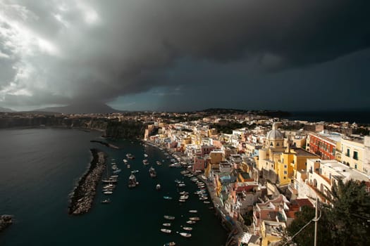 View of the Port of Corricella with lots of colorful houses on a sunny day in Procida Island, Italy.
