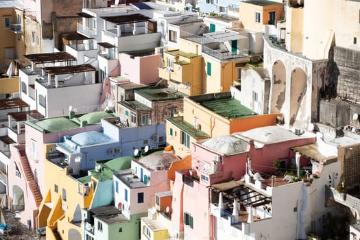 View of the Port of Corricella with lots of colorful houses on a sunny day in Procida Island, Italy.