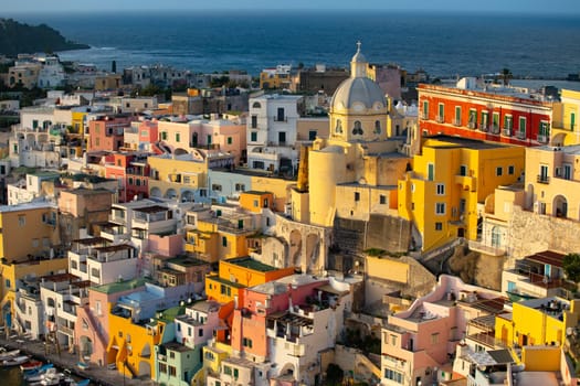 View of the Port of Corricella with lots of colorful houses in the sunset, Procida Island, Italy.