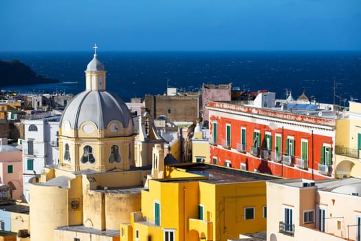 View of the Port of Corricella with lots of colorful houses on a sunny day in Procida Island, Italy.