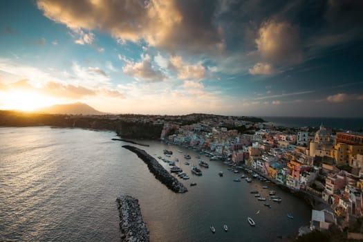 View of the Port of Corricella with lots of colorful houses in the sunset, Procida Island, Italy.