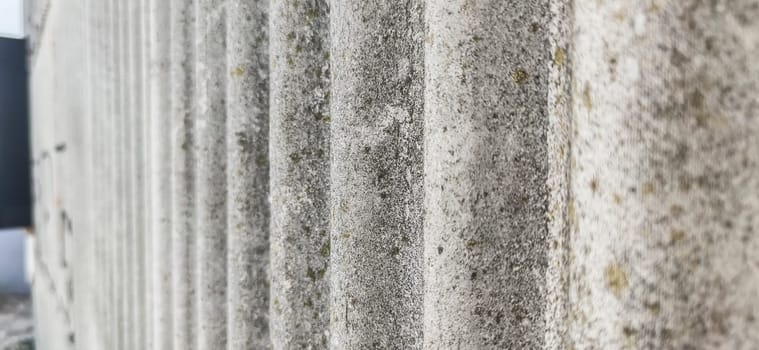 Wall protected with fibre cement corrugated sheets. Disused construction material for containing elements harmful to human health