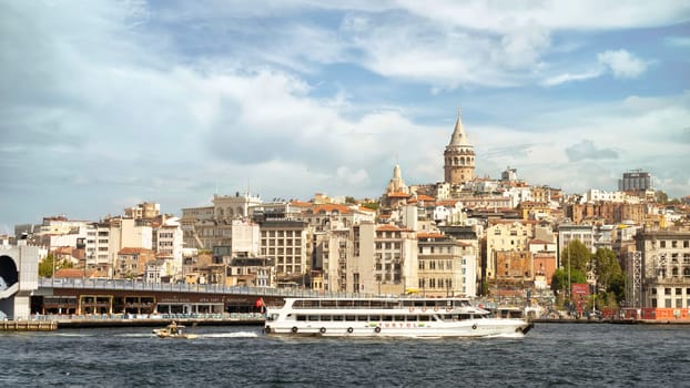 Ferry boat sailing in Bosphorus Strait, with Istanbul skyline in the background, overlooking Galata Bridge with traditional fish restaurants and Galata Tower, Istanbul, Turkey