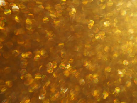 Bokeh light of gold glitters. Golden glitter texture background. Sparkling glitter wrapping paper with sequins and sparkles. Festive golden bokeh and glitter. Beautiful macro background.