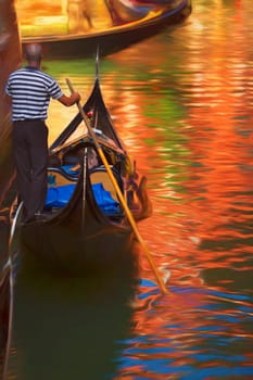 A gondolier takes his pasanger down the canals of Venioce Italy.