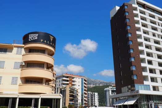 Budva, Montenegro, August 18, 2022. City life of Budva in the summer tourist season. Modern buildings, transport, people on the street go shopping, cafes. Sunny day. Tourism and active lifestyle