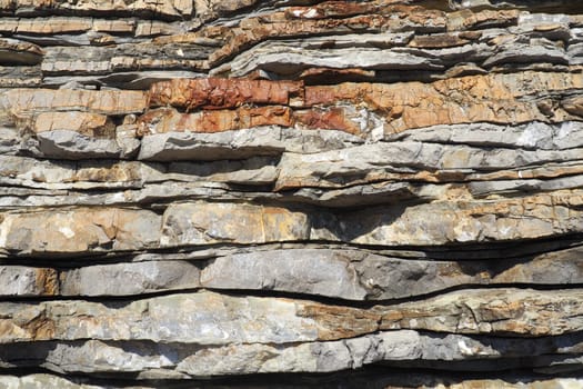 Flysch is a series of marine sedimentary rocks that are predominantly clastic in origin and are characterized by the alternation of lithological layers. Balkans, Montenegro, Budva, Mogren beach.