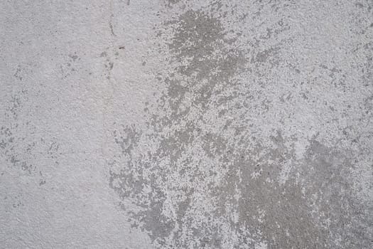 Plastered wall texture. Whitewash surface. Abstract background. Retro wall built structure texture. Cracks and bumps on the concrete wall. Uneven coloring with water-based paint. Old tattered plaster.