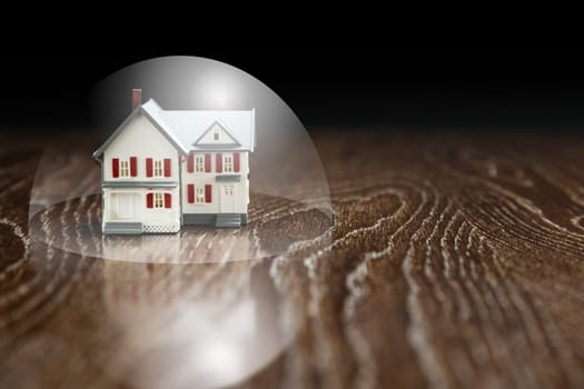 Model House on a Wooden Table Under a Protective Bubble.
