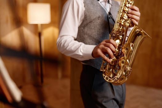 Cropped shot of young musician standing and playing saxophone. Musical jazz or blues performance