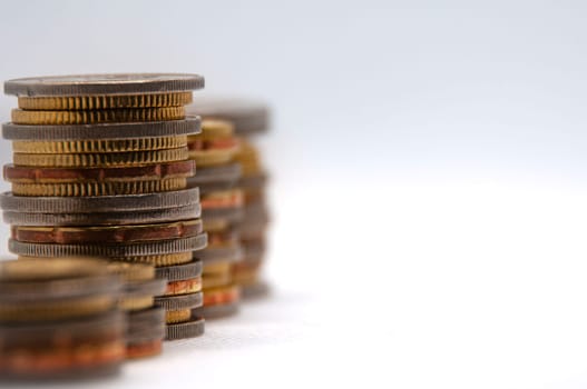 Close up of coins on white background with customizable space for text or ideas. Business and investment concept.