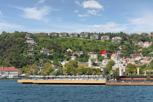 View from the sea of the green mountains of the Europian side of Bosphorus strait, with traditional houses and dense trees, in a summer day, Istanbul, Turkey