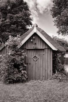 Wooden tool shed with thatched roof
