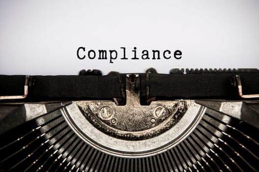 Compliance text text typed on an old vintage typewriter. Compliance concept