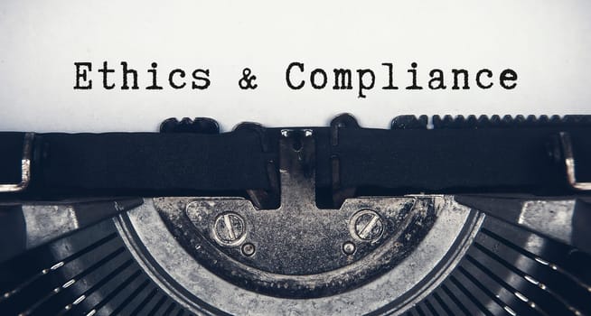 Ethics and compliance text typed on an old vintage typewriter.