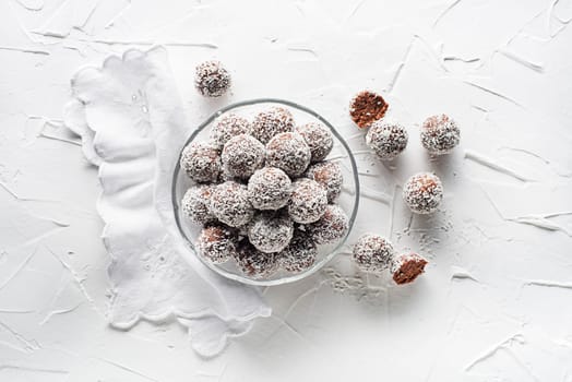 Delicious Coconut-Chocolate balls covered with grated coconut. Soft, delicious and fudgy coconut balls with rum, biscuit and chocolate