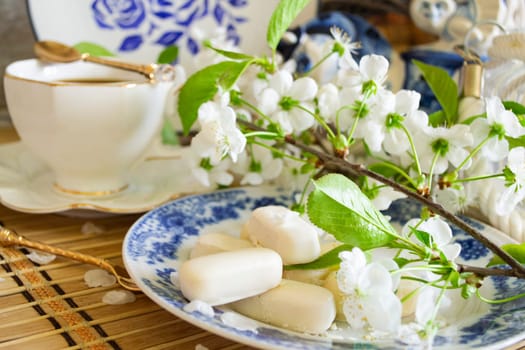 Fresh sweets on white plain dish and hot chocolate. Romantic brakefast with cherry flowers and vintage cup