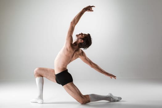 The young attractive modern ballet dancer over white background