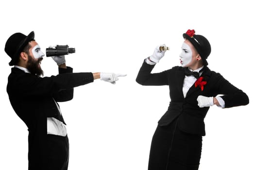 Two memes as business people looking at each other through binoculars isolated on white background. concept of suspicion and mistrust