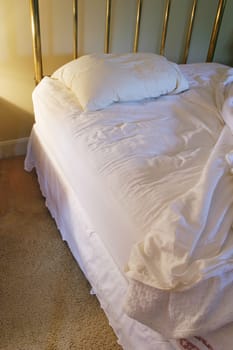 Unmade brass bed, lonely.