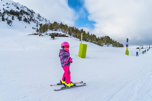 Young skier, a child, having fun on ski riding towards ski drag lift. Winter holidays in El Tarter, Andorra, Pyrenees Mountains, Grandvalira