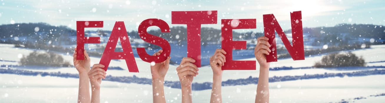 People Hands Holding Red German Word Fasten Means Fasting. Snowy Winter Background With Snowflakes