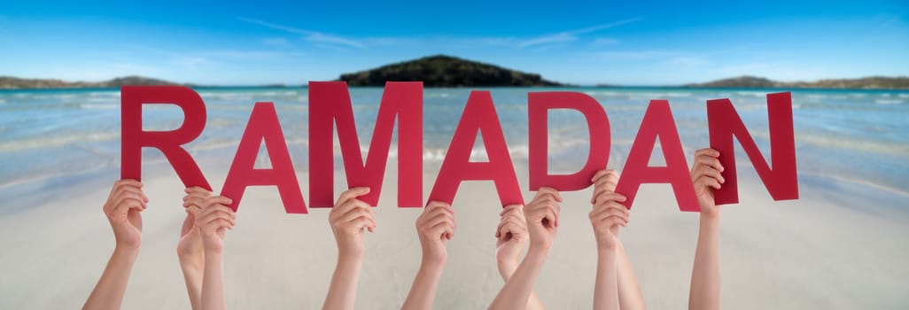 People Hands Holding Red English Word Ramadan. Ocean And Beach As Background