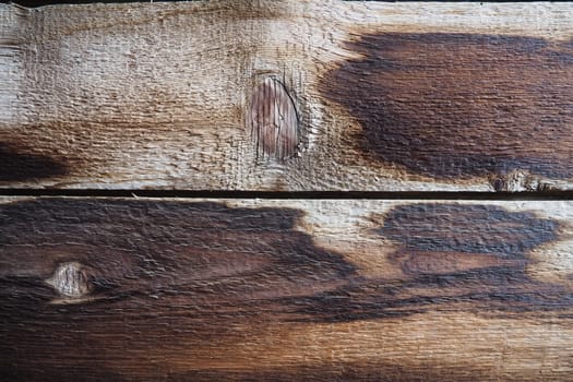 Burnt scorched horizontal boards background. Wooden background close-up with black burnt spots