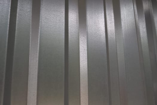 aluminum chrome metal profiled sheet with vertical stripes. metallic gray.