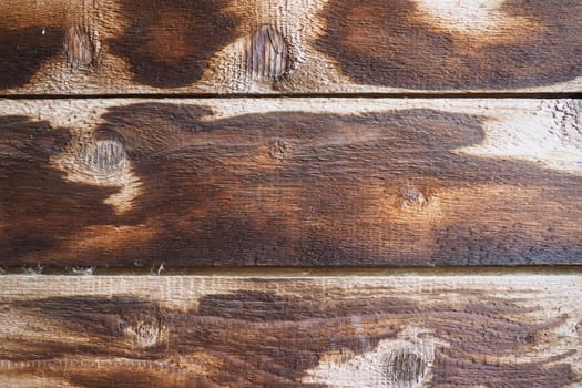 Burnt scorched horizontal boards background. Wooden background close-up with black burnt spots
