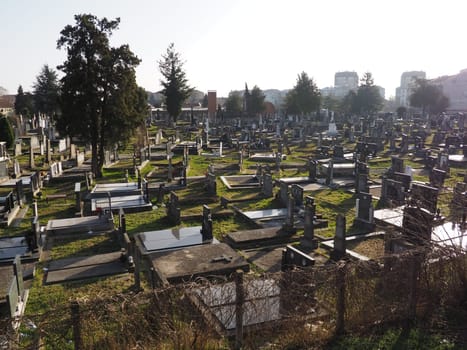 Sremska Mitrovica, Serbia, February 25, 2021. Christian city modern cemetery. Graves with stone monuments and crosses. Granite headstones. Crypt or chapel. Funeral or Halloween theme.