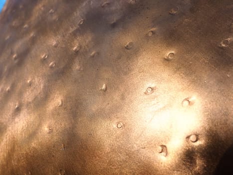 Metal bronze textured plate. Bronze or copper polished surface with dents, scratches and indentations. Metal texture.