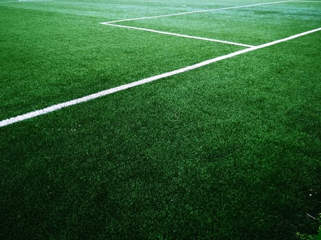 The marking of the football field on the green grass. White lines no more than 12 cm or 5 inches wide. Football field area