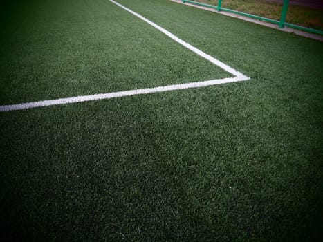 The marking of the football field on the green grass. White lines no more than 12 cm or 5 inches wide. Football field area