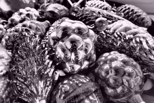 New Year and Christmas tree decorations, glass balls in the form of cones and baskets. Cones and pendants shiny tinsel. Festive background. Lots of Christmas decorations. Black and white monochrome.
