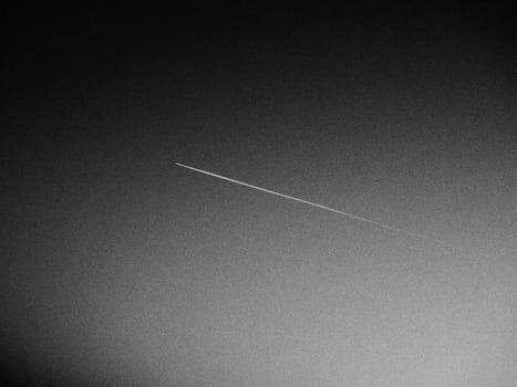 the plane and the trail in the sky is black or gray. Abstract background on a space or aero theme. Increased graininess. Light gradient.